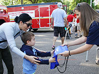 Photo of a woman and child receiving a free tote bag during Governor’s Fire Prevention Day at the Minnesota State Fair.