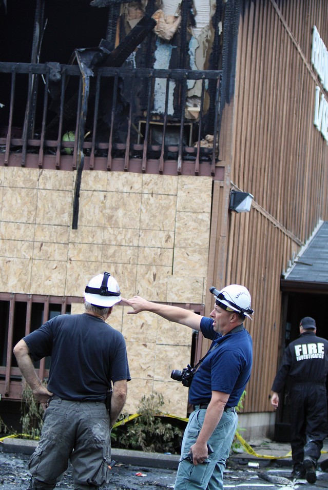 Investigators at the scene of a fire with local law enforcement officials.