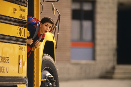 kid peeking his head out from a school bus door