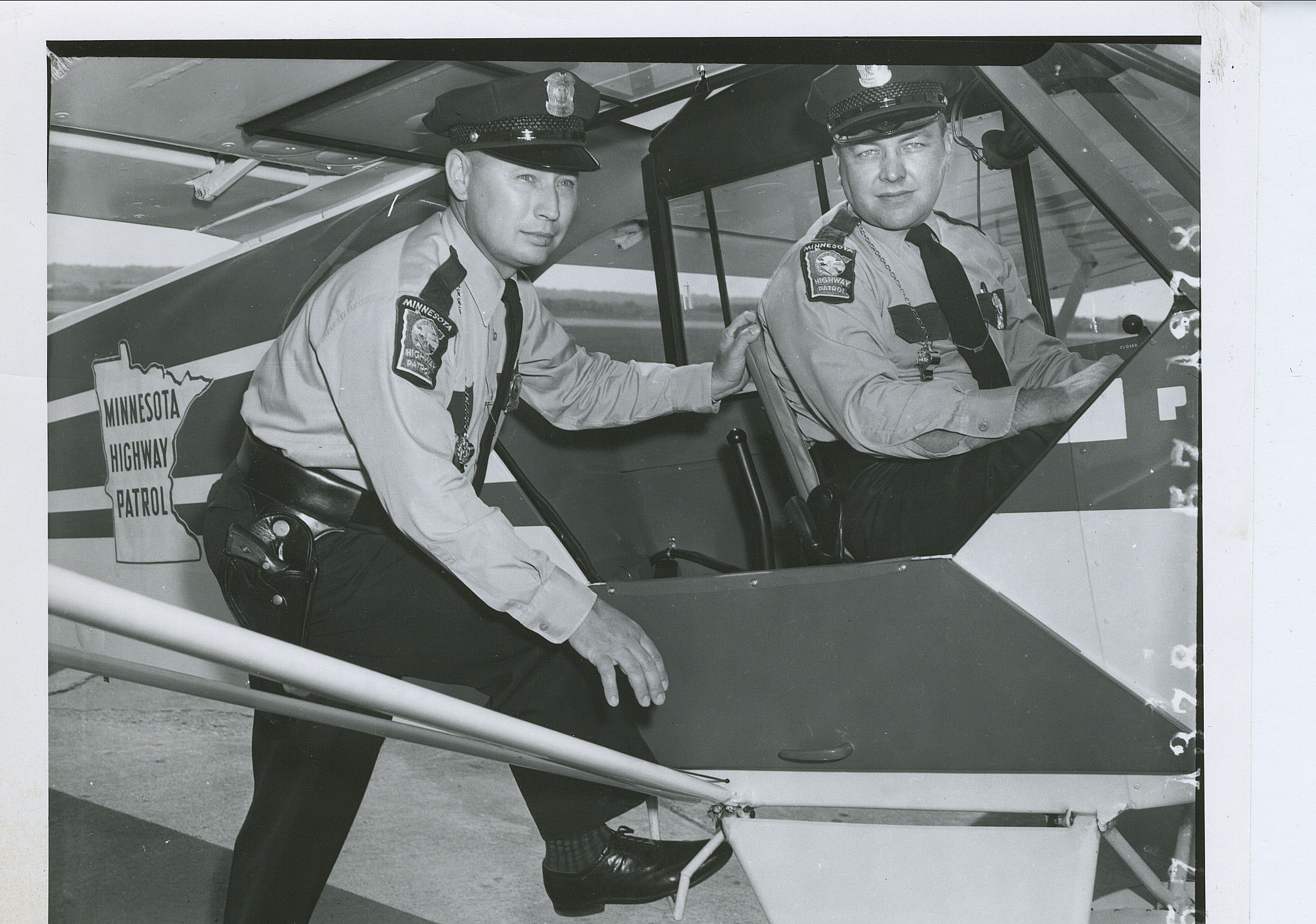 Two troopers posing with an early fixed-wing aircraft