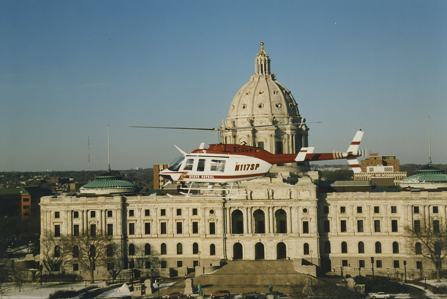 An early state patrol helicopter hovering near the Minnesota Capitol building