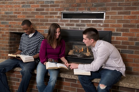Students warming up by a fireplace. 