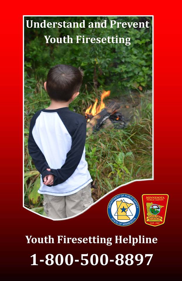Photo of kid standing and looking at fire.